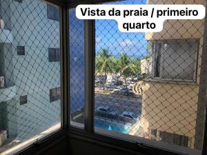 a glass window with a view of a pool at Beira-mar na praia de pajuçara com Dois quartos - Apto 304 in Maceió