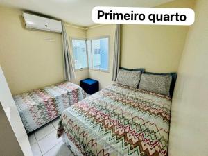 a small bedroom with two beds and a window at Beira-mar na praia de pajuçara com Dois quartos - Apto 304 in Maceió
