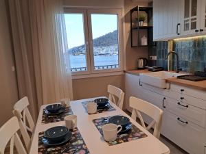 a kitchen with two tables and chairs and a window at Yatrissa Boutique Apartments in Kalymnos