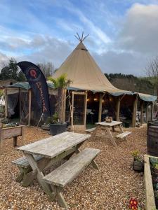 Herons Lake Retreat Lodges في Caerwys: خيمة مع طاولة نزهة وجلسة نزهة