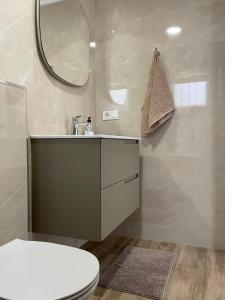 a bathroom with a toilet and a sink and a mirror at Villa Suérte del Mar in Torrevieja