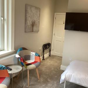 um quarto com uma cama, uma cadeira e uma mesa em Belford House Self Check-in Rooms em Haltwhistle