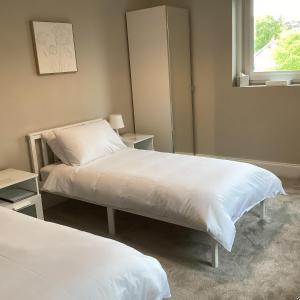 a bedroom with two beds and a mirror at Belford House Self Check-in Rooms in Haltwhistle