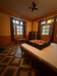 een slaapkamer met een bed en een plafondventilator bij Ohana cafe & homestay in Kasol