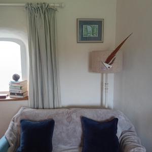 a living room with a couch and a clock on the wall at Quincecote mini guest wing in Hartland