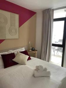 Stunning lovely flat with Pool and strong Wi-Fi في أرونا: غرفة نوم بسرير كبير عليها منشفتين