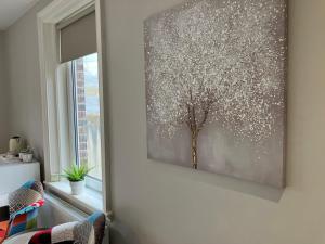 un quadro di un albero su un muro accanto a una finestra di Belford House Self Check-in Rooms a Haltwhistle