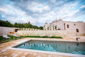 a house with a swimming pool in the yard at Trulli Magravì - Apparthotel in Alberobello