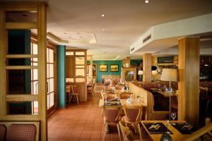 a dining room with tables and chairs in a restaurant at Strandhotel Seehof in Langlau