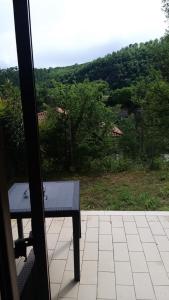 un banc installé sur une terrasse couverte avec vue sur les arbres dans l'établissement Casa Nina, à Borgo a Giovi