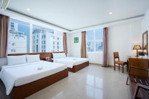 Postel nebo postele na pokoji v ubytování Golden Light Da Nang Hotel