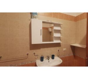 ein Bad mit einem Waschbecken und einem Spiegel in der Unterkunft A Due Passi da in Merine