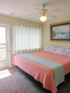 sypialnia z łóżkiem i wentylatorem sufitowym w obiekcie Beach Bliss w mieście Kill Devil Hills