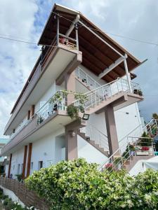 - un bâtiment blanc avec un balcon et des escaliers dans l'établissement Anel Suites, à Vlorë