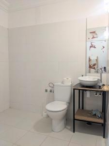 La salle de bains blanche est pourvue de toilettes et d'un lavabo. dans l'établissement Dar Randigaba, à Taroudant