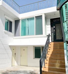 una casa blanca con una puerta negra y escaleras en Soft Seoul Hongdae, en Seúl