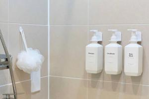 tres botellas de odorizantes en una pared en un baño en Soft Seoul Hongdae, en Seúl