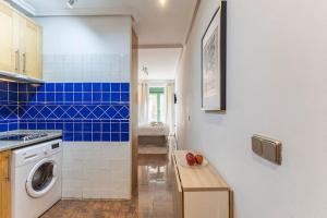 een keuken met een wasmachine en blauwe tegels bij Apartamento en Madrid Centro in Madrid