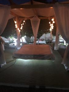 een bed in een tent met verlichting en gordijnen bij Converted Shed Studio & Garden Hanging Bed in Porto Rafti