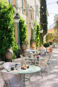 an outdoor patio with tables and chairs with food on them at La Magdeleine - Mathias Dandine in Gémenos