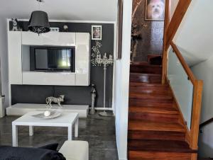 a living room with a television and a stairway at La Mar de Bonita in Tagle