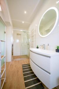 un baño con lavabo y espejo en Lady D, en Betina 46 fotos más