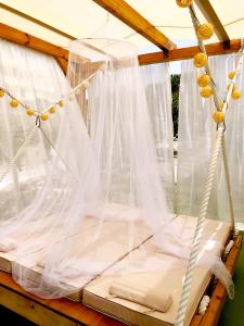 a bed with white mosquito netting on a porch at Converted Shed Studio & Garden Hanging Bed in Porto Rafti