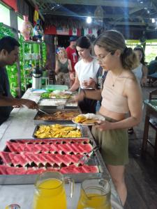a woman standing in front of a buffet of food at Bromelia Flower Lodge Iquitos in Iquitos
