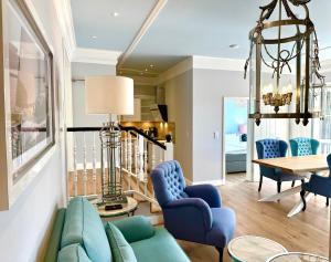 a living room with blue chairs and a table at Apartmenthaus Luv un Lee in Langeoog