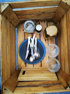 einen Holztisch mit einer blauen Platte und Küchenutensilien in der Unterkunft Glamping Kaliska in Łochów