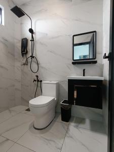 uma casa de banho com WC e uma televisão na parede em Klebang 9 Villa MuslimOnly em Malaca