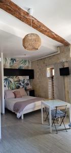 a bedroom with a large bed and a table at Au logis de Pézenas in Pézenas