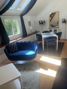 uma sala de estar com um sofá azul e uma mesa em Maison cosy avec extérieur et piscine partagée em Mespaul