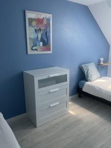 a bedroom with a white dresser and a bed at Maison cosy avec extérieur et piscine partagée in Mespaul