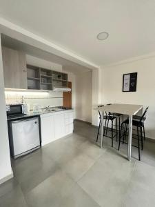 a kitchen with a table and a table and chairs at Apart Goleta Florencia in Ushuaia +5 photos