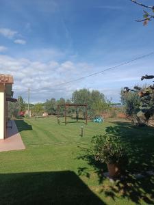 un parc avec une balançoire installée dans la pelouse dans l'établissement Agriturismo Le Villette di Cate, à Alberese