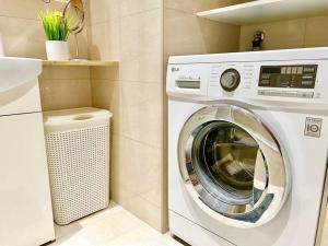 Waschmaschine und Trockner im Bad mit Waschbecken in der Unterkunft 90 m2 Premium Apartment with Balcony in Wien