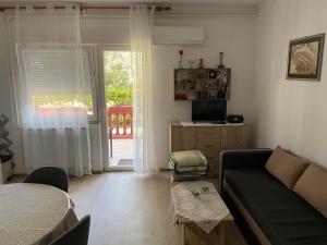 a living room with a couch and a window at Apartman 3D in Krk