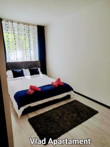 a bedroom with a bed with red shoes on it at Vlad Apartament in Braşov