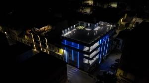 una vista aérea de un edificio por la noche con luces azules en After Sun, en Patti