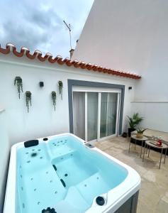 une baignoire jacuzzi devant un bâtiment blanc dans l'établissement Cartaxo Riverside - Villa with Jacuzzi few minutes from Lisbon, à Cartaxo