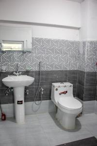 y baño con aseo y lavamanos. en Al Jannat Hotel & Relax Inn Guest House Skardu en Skardu