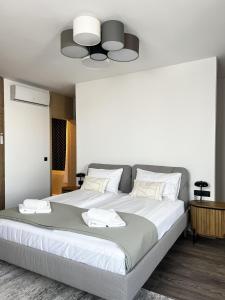 a large bed with white sheets and a ceiling at MT SUITES BUDAPEST in Budapest