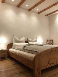 a bedroom with a wooden bed with two pillows at Haus Bliestal-Blick in Blieskastel