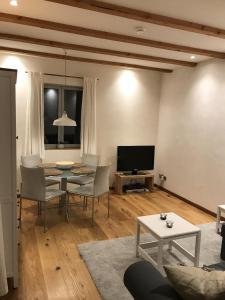 Una sala de estar con una mesa y sillas y un televisor. en Haus Bliestal-Blick, en Blieskastel