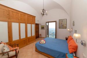 a bedroom with a blue bed and a balcony at Casa Stella di mare in Positano