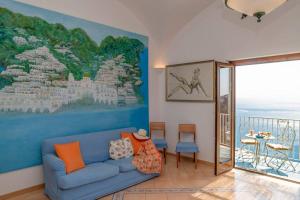a living room with a blue couch and a painting at Casa Stella di mare in Positano