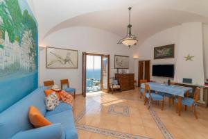 a living room with a blue couch and a table at Casa Stella di mare in Positano