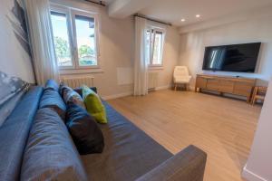 a living room with a blue couch and a flat screen tv at Baltasar Etxabe - ONGI ETORRI in Zumaia