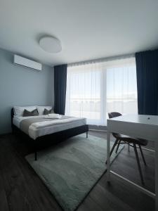 a bedroom with a bed and a table and a desk at MT SUITES BUDAPEST in Budapest